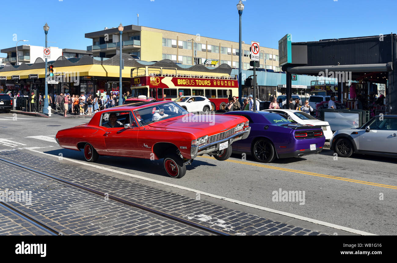 SAN FRANCISCO, CA/USA - 30. APRIL 2017: Mexikanische Amerikaner fahren einen roten Chevrolet Impala lowrider in den Straßen von San Francisco. Stockfoto