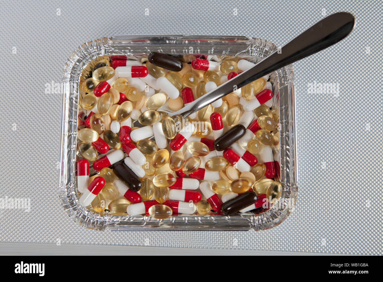 Eine Auswahl an verschiedenen Pillen in einem fast food Container. Stockfoto