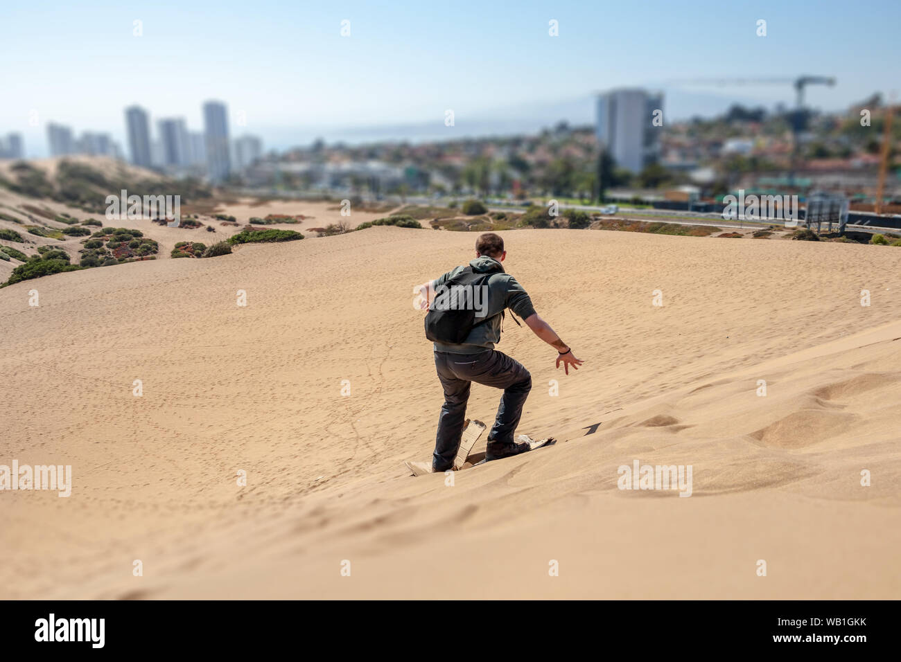 Junge kaukasier Männlich traveler Sandboarding an Concon Sanddüne in Vina del Mar, Chile Stockfoto