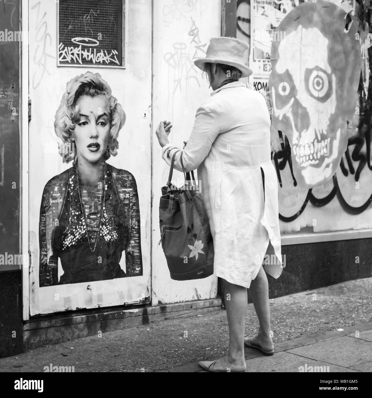 Seltsam gekleidete Dame stand vor der Marilyn Graffiti Stockfoto