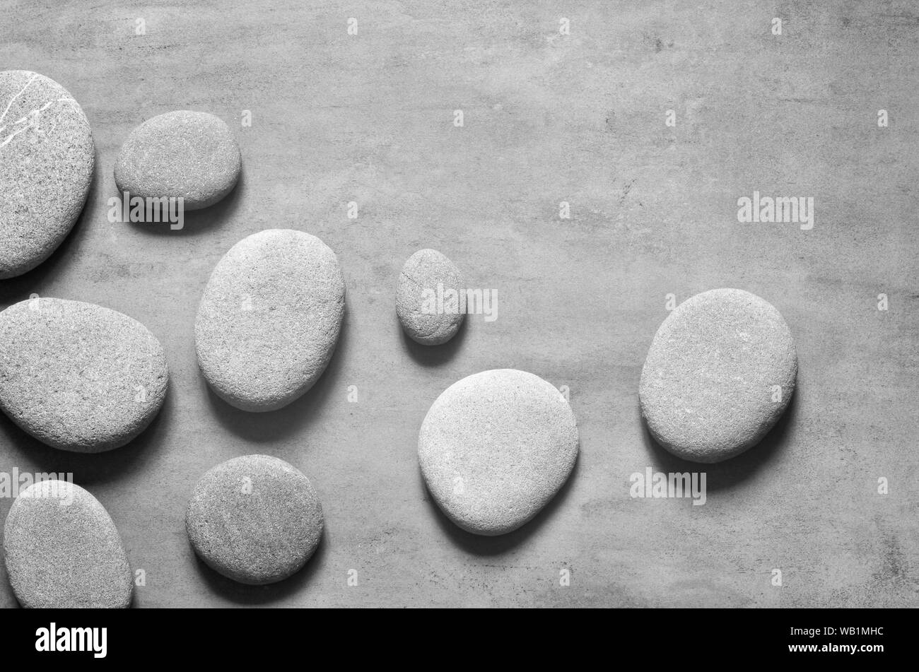Flach Zusammensetzung mit grauen spa Steine auf grauem Hintergrund. Stockfoto