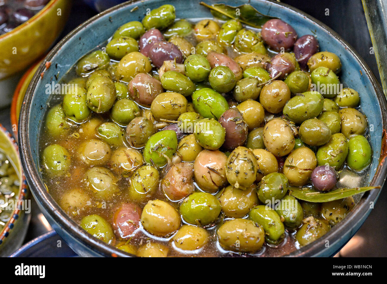 Marinierte Oliven mit Kräutern auf dem Markt. Stockfoto