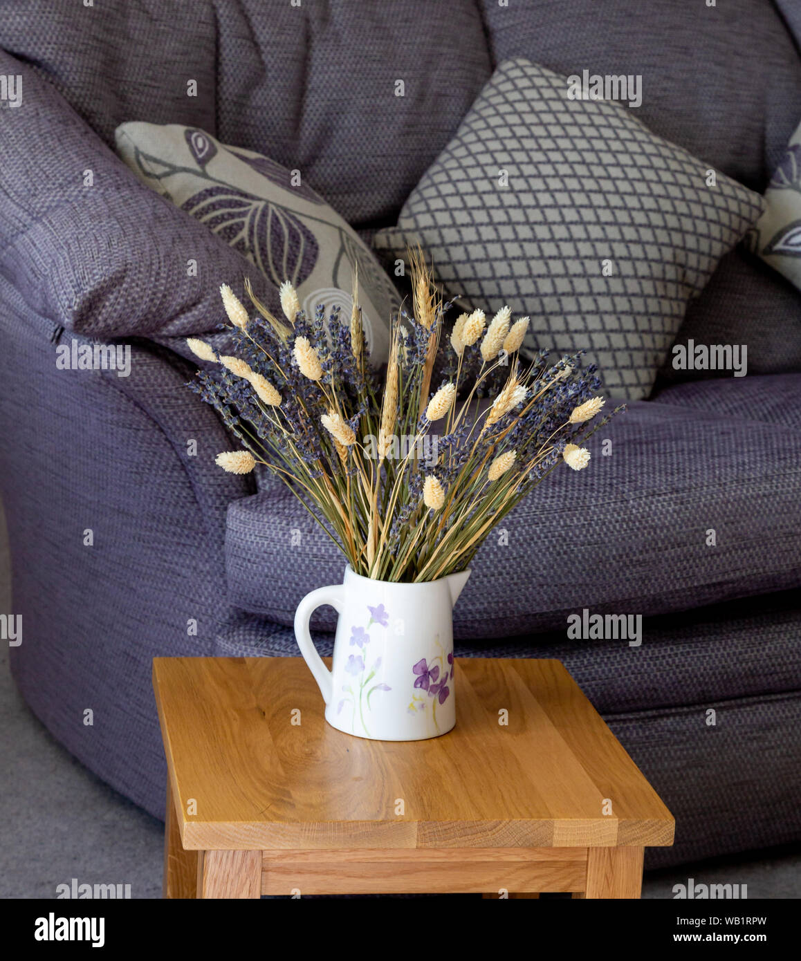 Getrocknetem Lavendel und getrockneten Gräsern in einem Krug in einem modernen Ambiente. Stockfoto