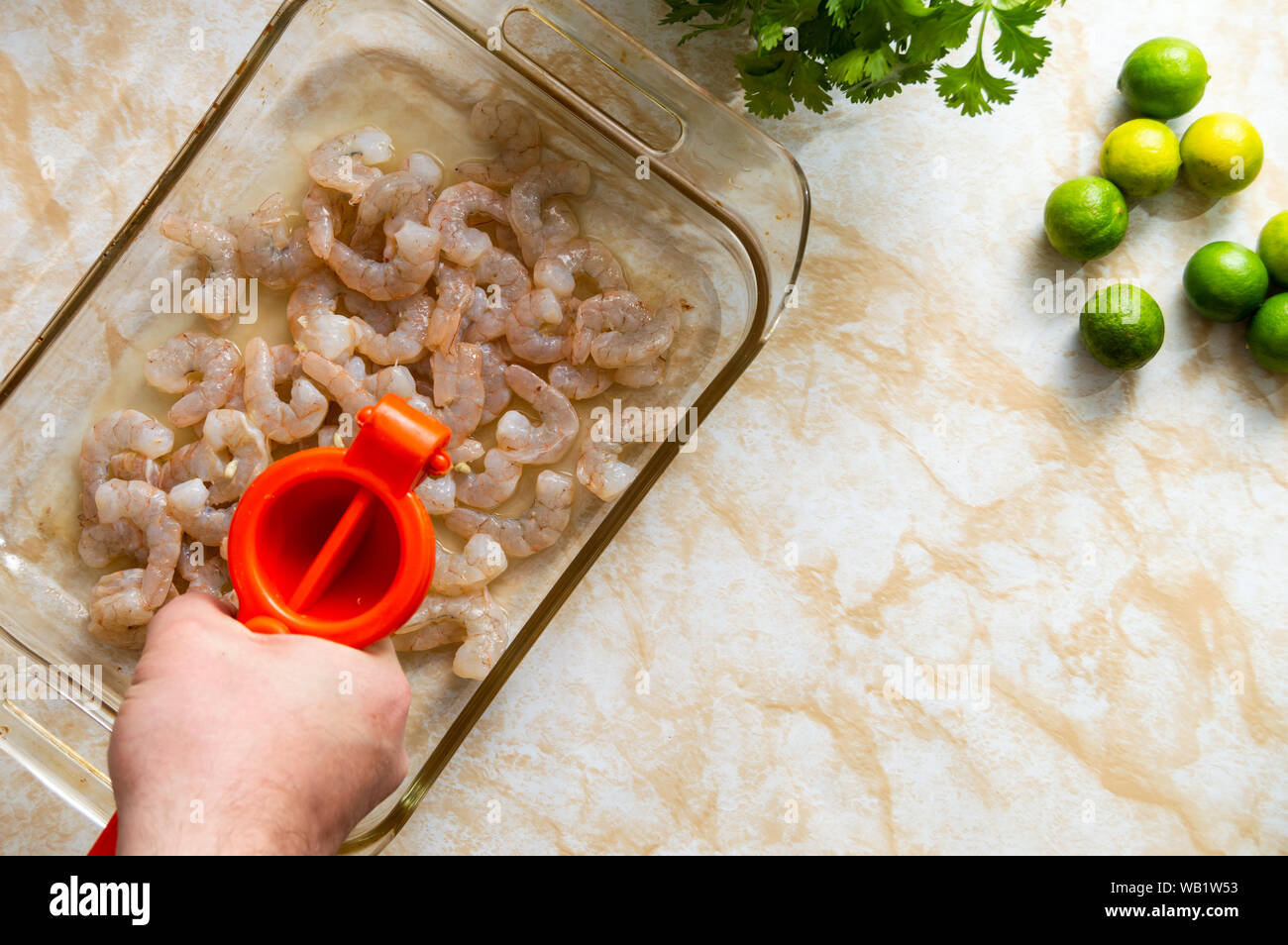 Drücken Limettensaft über Garnelen, eine der Etappen der Lateinamerikanischen Meeresfrüchte Teller bekannt als Ceviche Stockfoto