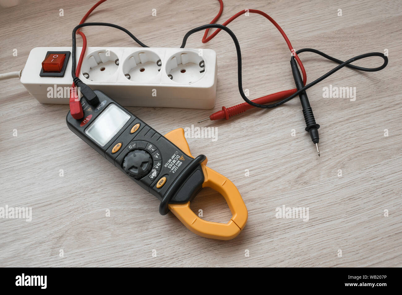 Stromzange mit Power Strip auf dem hölzernen Tisch Stockfoto