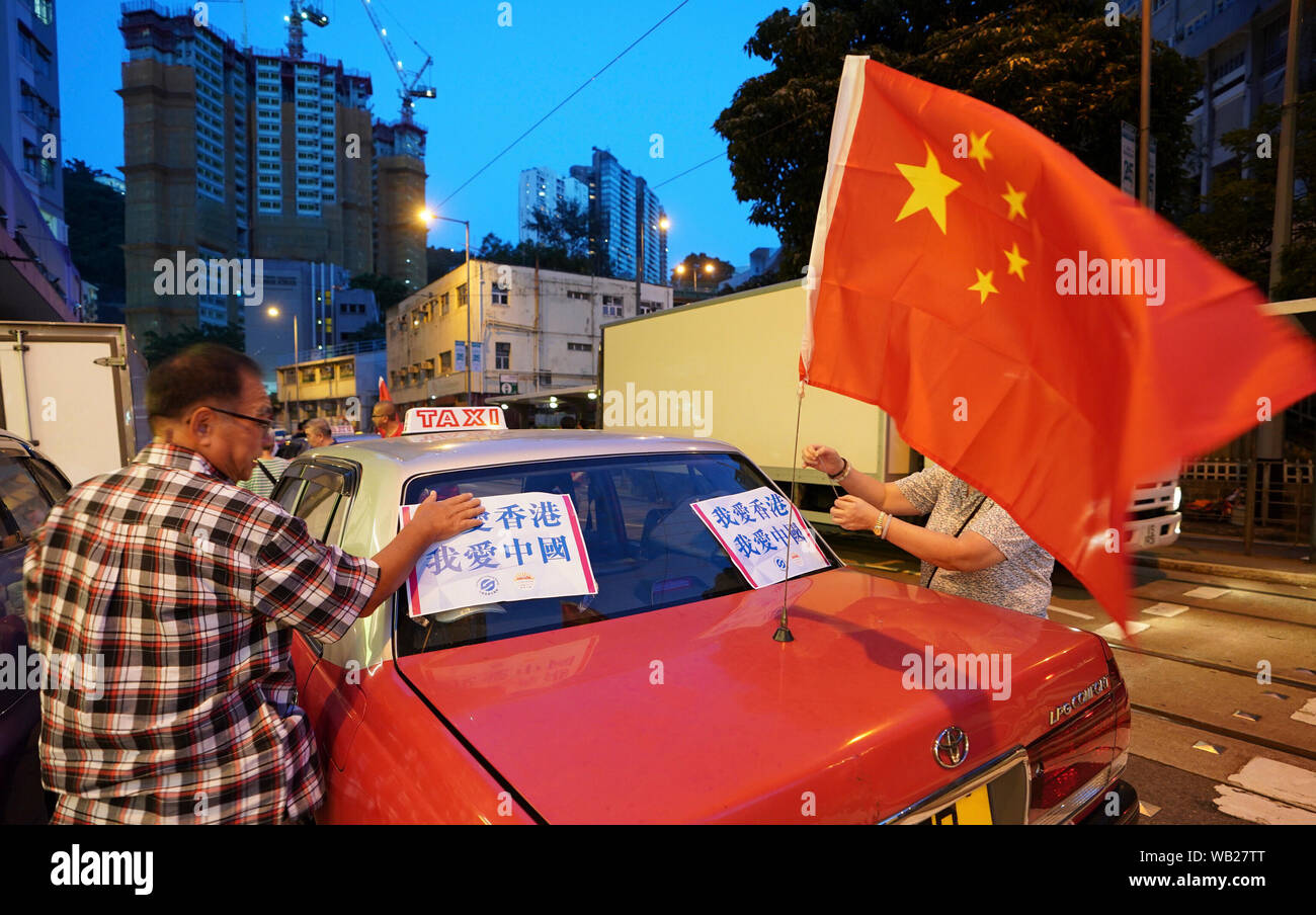 (190824) - HONGKONG, Aug 24, 2019 (Xinhua) -- ein Mann hält ein Plakat lesen "ich Hong Kong Liebe. Ich liebe China." zu einem Taxi während einer Kundgebung in Hong Kong, South China, 23.08.2019. Fast 600 Taxis am Freitag nahmen hier an einer Kundgebung gegen Gewalt und zeigten Bewohner von Hongkong "Liebe zur Heimat und der Heimat. Die Sammlung, von der Gruppe sicherzustellen und Hong Kong Hong Kong Taxi Fahrer und Unternehmen organisiert, die darauf abzielt, wurde auf Drängen des Hong Kong Gemeinschaft gemeinsam gegen Gewalt und soziale Ordnung so bald wie möglich wiederherzustellen, teilten die Veranstalter mit. (Xinhua / Qi Stockfoto