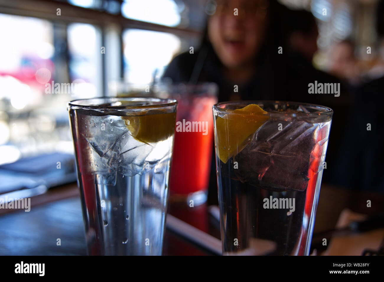 Gläser iced kaltes Wasser mit Zitronen auf einem Tisch im Restaurant mit einem zufriedenen Kunden Geselligkeit mit Freunden. Stockfoto