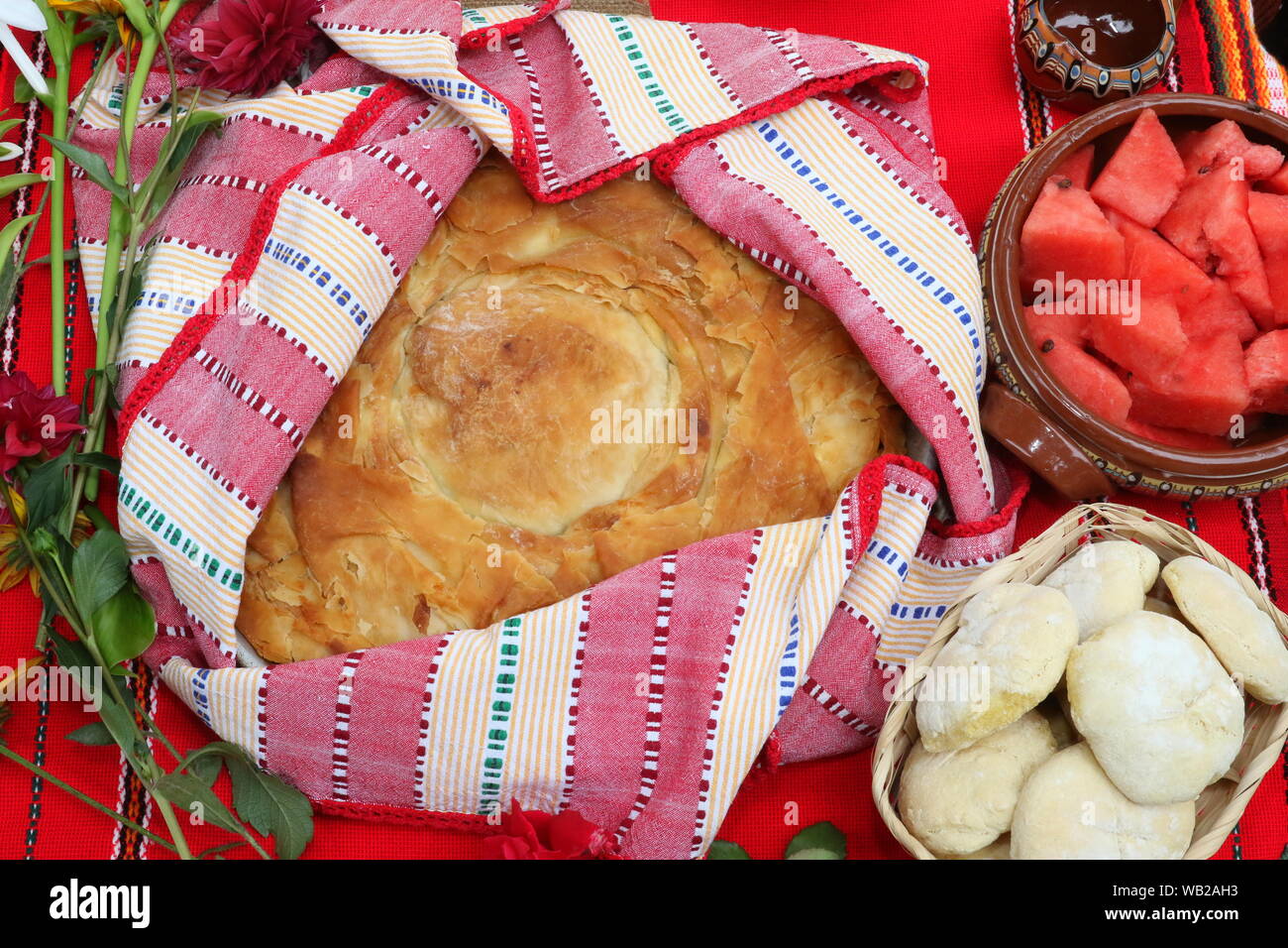 Frisch gebackenes Brot in der traditionellen bulgarischen Textilien angeordnet. Bild von leckeren hausgemachten Backwaren. Frisches Brot Stockfoto