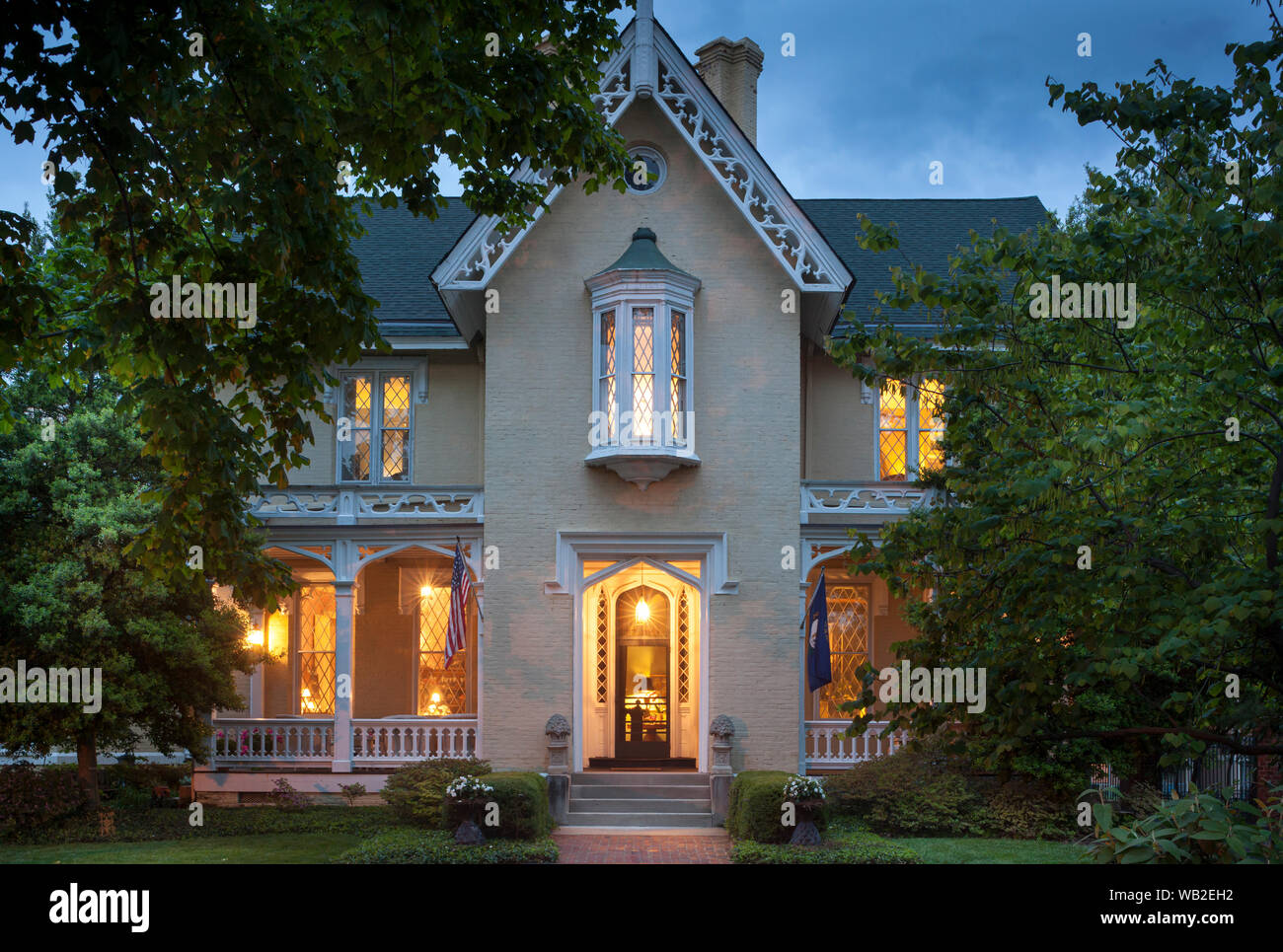 Fassade des Hauses mit Fahnen und Garten im Sommer bei Nacht, American Gothic Revival Stil, Inn at Woodhaven, Louisville, Kentucky, USA Stockfoto
