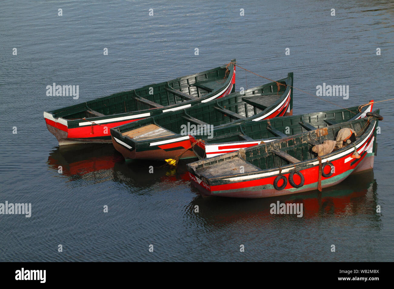 Marokko, El Jadida. Eine kleine Flotte von typischen roten und grünen Holzboote liegt im alten Hafen. UNESCO-Weltkulturerbe. Stockfoto
