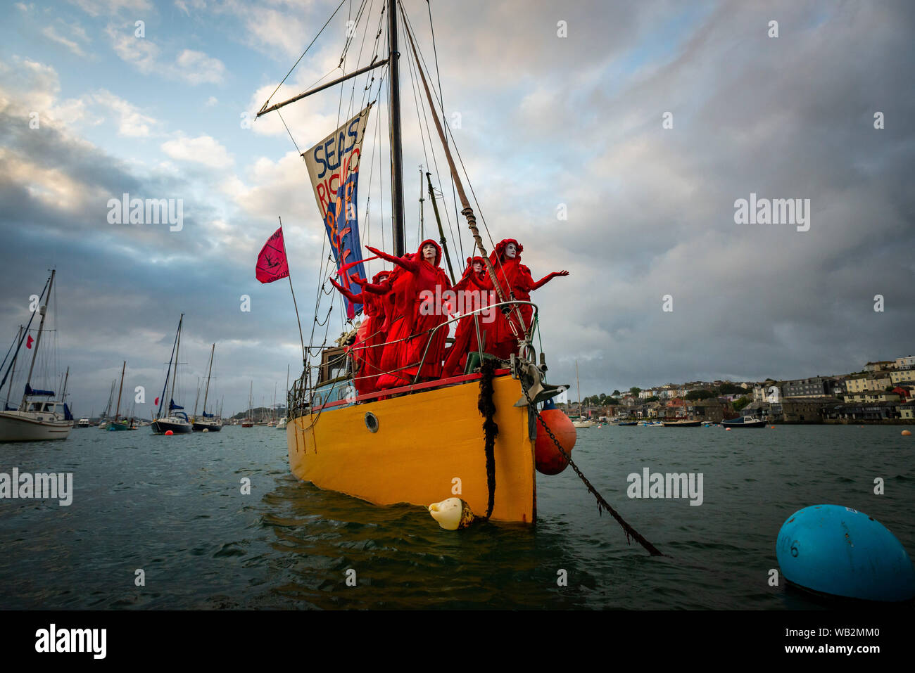River Fal, Falmouth, Cornwall, UK. Leistung protest Truppe der Roten Rebellen Brigade segeln entlang des Flusses Fal das Bewusstsein für die Klimakrise. Stockfoto