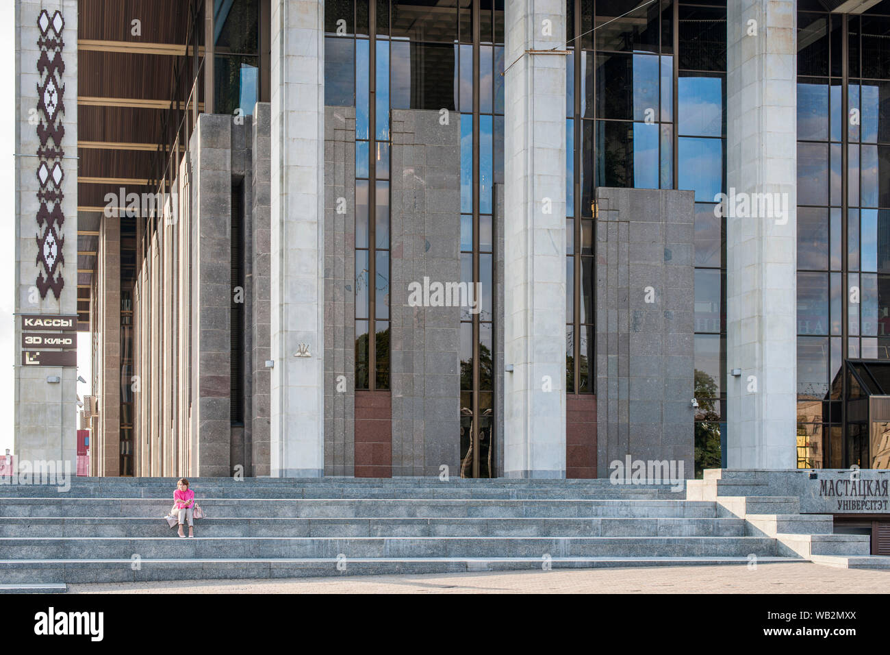 Eine Frau auf der Treppe des Palastes der Republik in Minsk, Weißrussland sitzen. Stockfoto