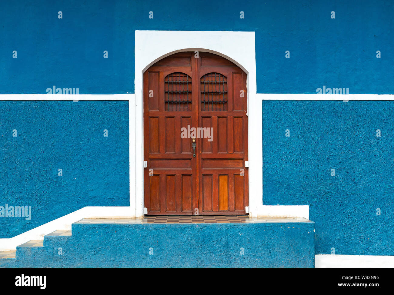 Fassade mit blauer Wand und Holztür im historischen Stadtzentrum von Granada in spanischer Kolonialarchitektur, Nicaragua. Stockfoto Fassade mit blauer Wand und Holztür im historischen Stadtzentrum von Granada in spanischer Kolonialarchitektur, Nicaragua. Stockfoto