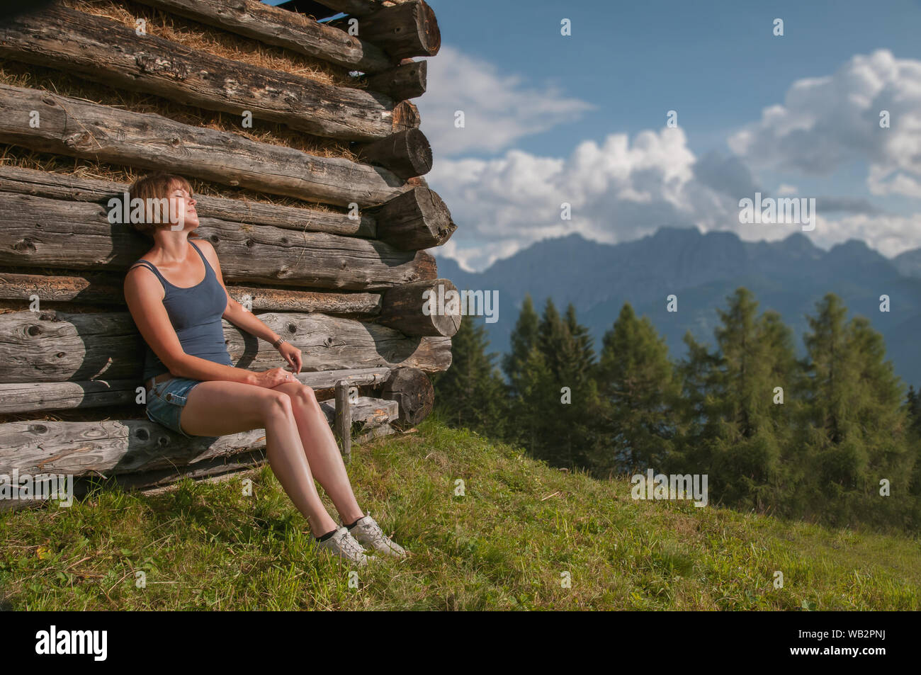 Junge Frau nimmt Sonnenbaden in den österreichischen alpen Stockfoto