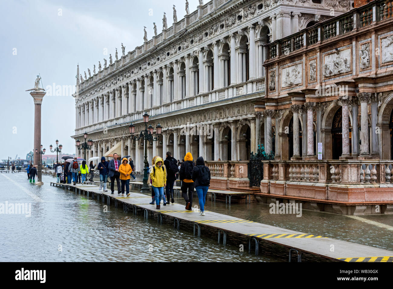 Menschen zu Fuß auf erhöhten Plattformen während der Acqua Alta (hohe Wasser) Veranstaltung, die in der Biblioteca Gebäude, Piazzetta di San Marco, Venedig, Italien Stockfoto