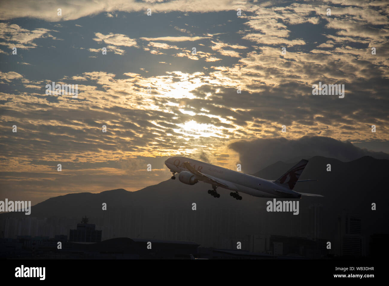 HONG KONG, circa 2017: Katar Airline Flugzeug weg vom Flughafen Hong Kong mit einem schönen bewölkter Sonnenuntergang auf dem Hintergrund Stockfoto