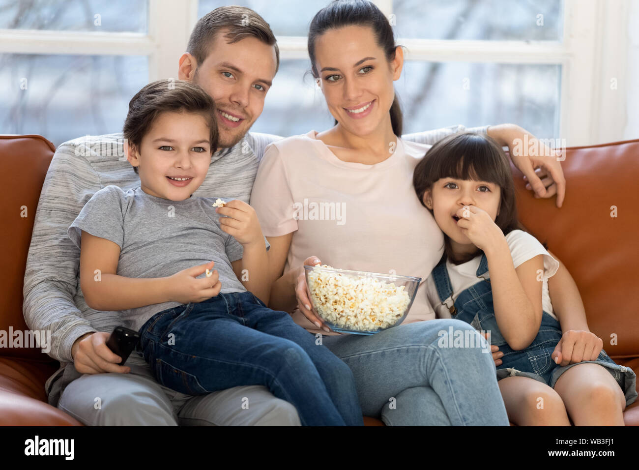 Glückliche Familie, Mama, Papa und Kinder Fernsehen zusammen Stockfoto