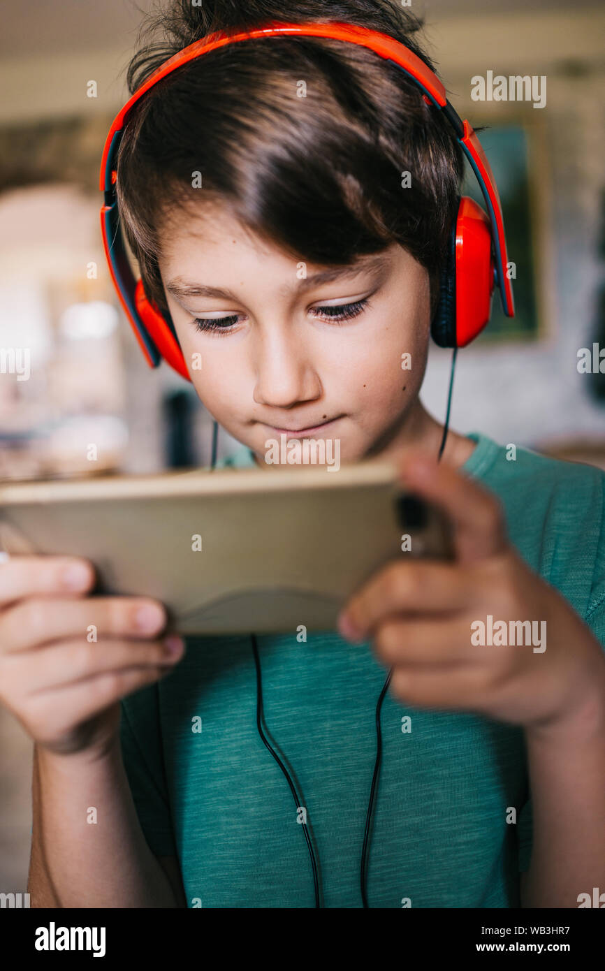 Acht Jahre alten Jungen in seinem Hause spielt Videospiel Stockfoto