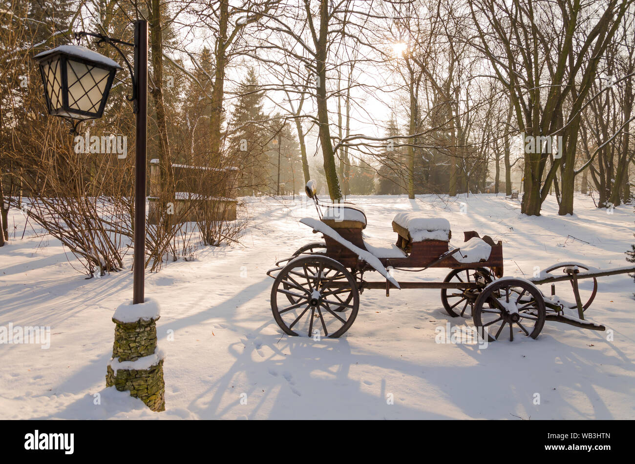 Warenkorb vernachlässigt und ein retro style Laterne in die verschneite Landschaft im Wald am späten Nachmittag vor Sonnenuntergang Stockfoto