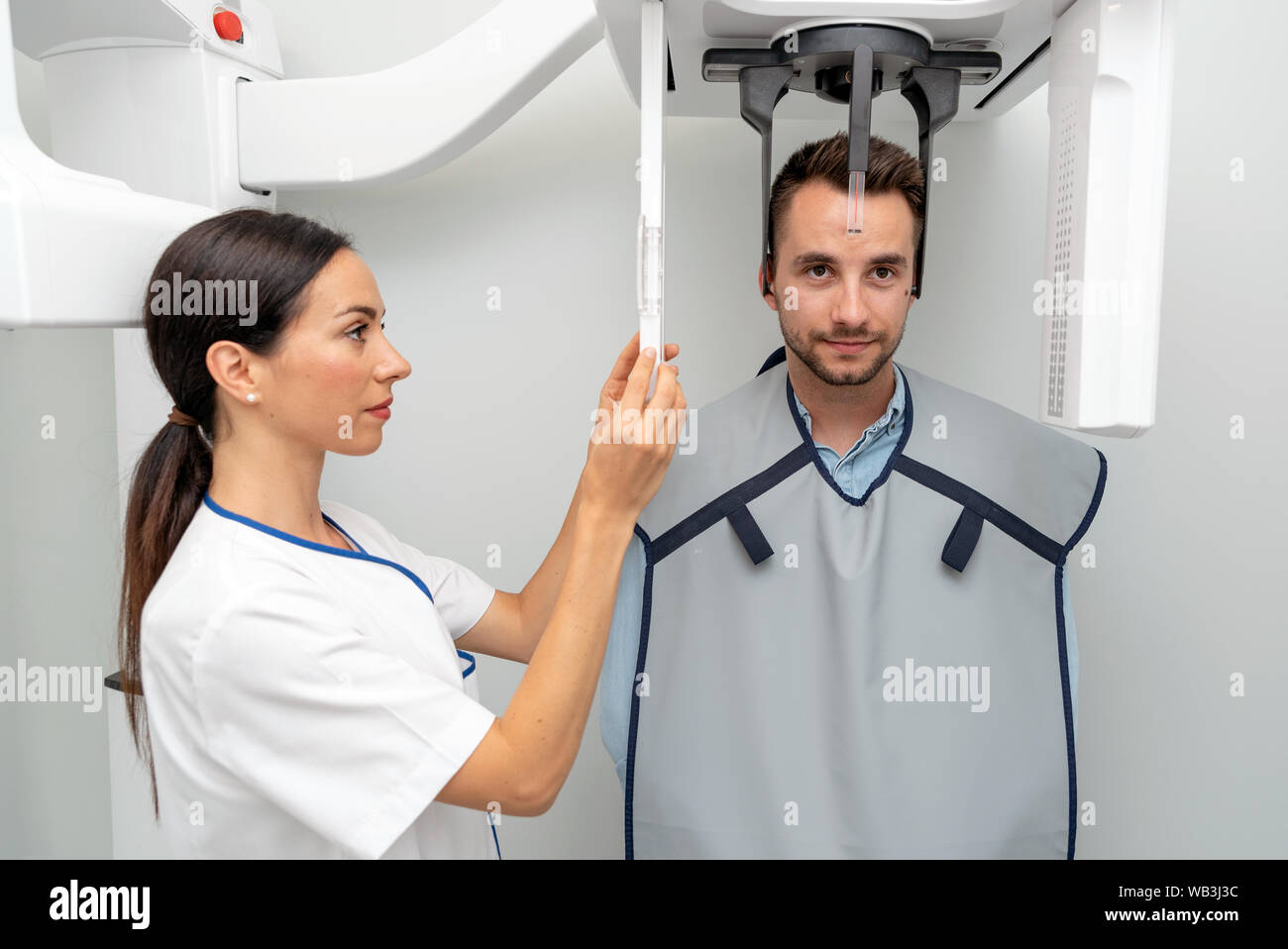 Schöner Mann stehenden Patienten in x-ray Machine. Panoramablick radiographie an professionelle zahnmedizinische Klinik. Stockfoto