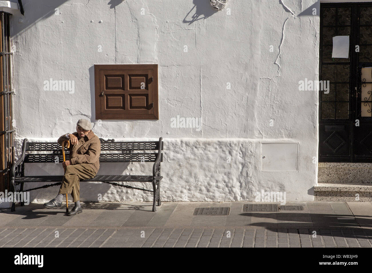 Alter Mann auf einer Bank sitzen in Mijas, Spanien Stockfoto