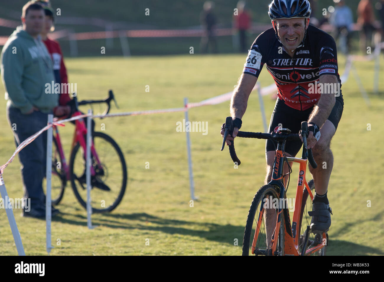 Hintergrundbeleuchtung cyclocross Rider suchen Wie seine verletzen Stockfoto