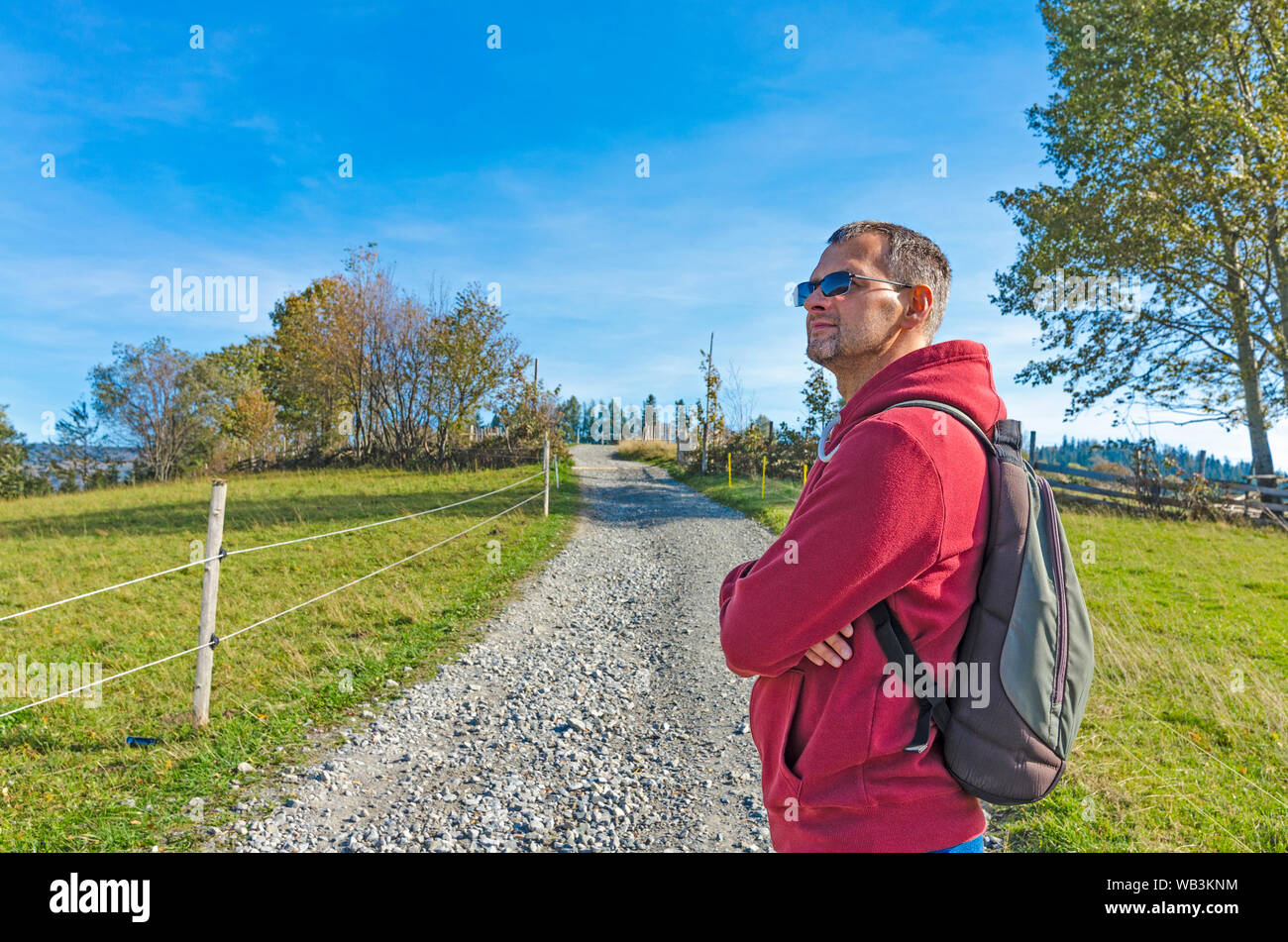 Ein Mann mit einem Rucksack auf einer Landstraße zwischen Autun farbige Natur Stockfoto