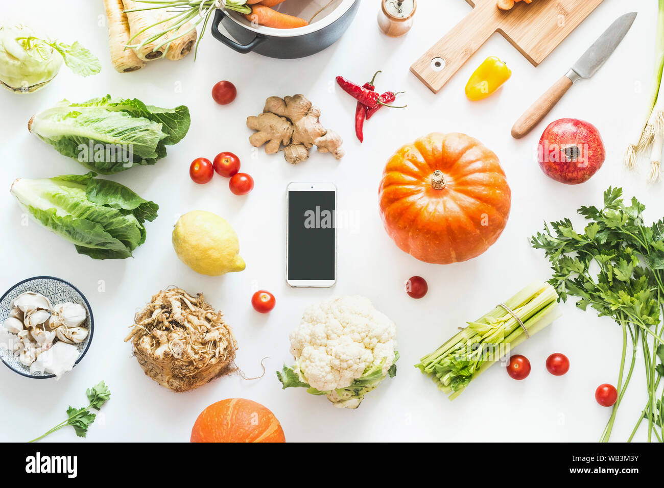 Herbst kochen Flach mit Smartphone mit leeren Bildschirm. Verschiedene saisonale Herbst Gemüse Zutaten und Kürbis auf weißem Hintergrund, top v Stockfoto