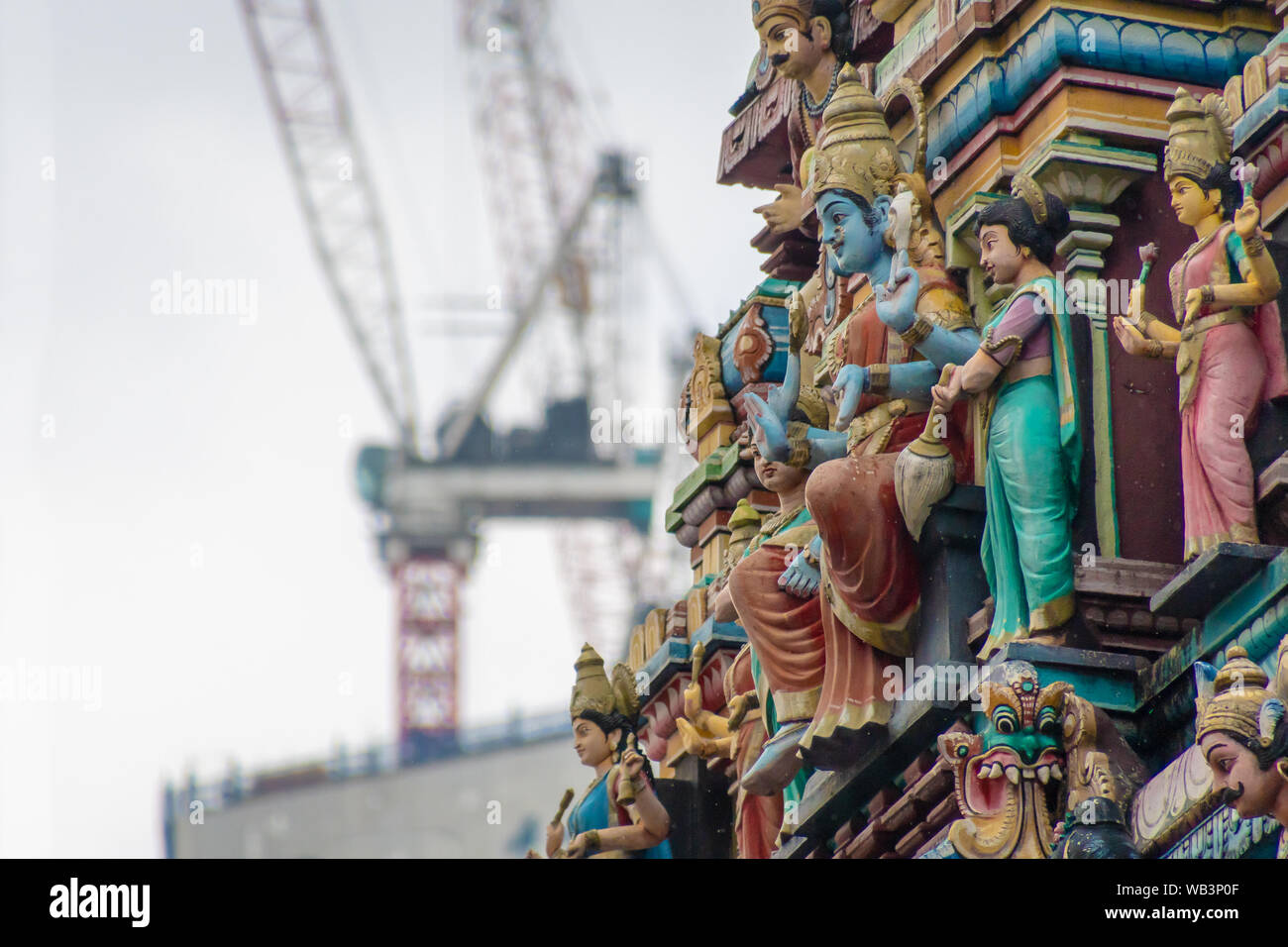 Sri Mahamariamman Tempel Ornamente der Struktur im Gegensatz zu Baukräne im Hintergrund in Malaysia Stockfoto