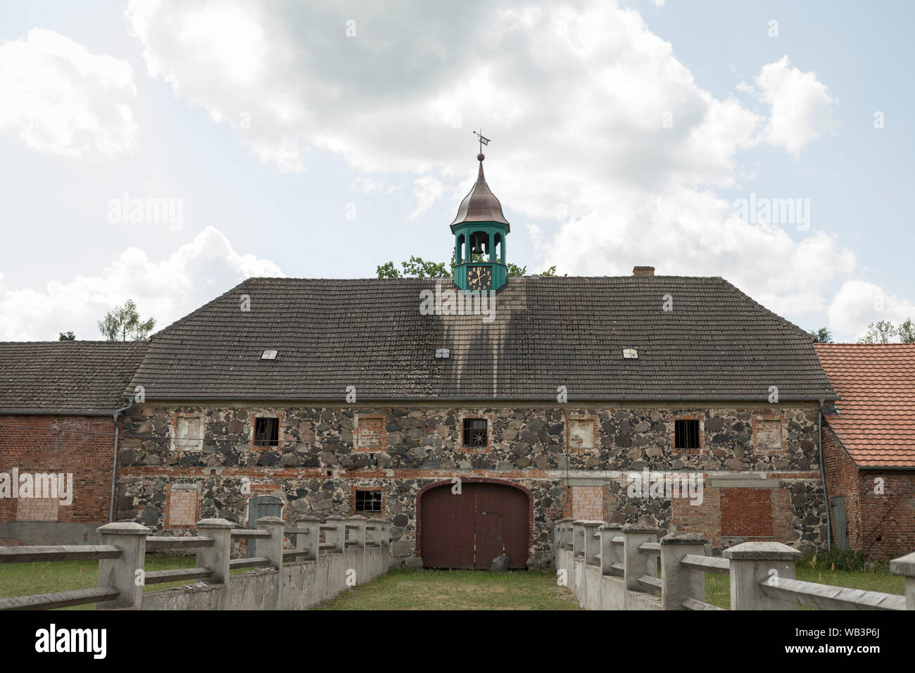 Alte Stein und Ziegeln Bauernhof mit Turm und eine Uhr an Schenkendobern, Land Brandenburg, Deutschland Stockfoto