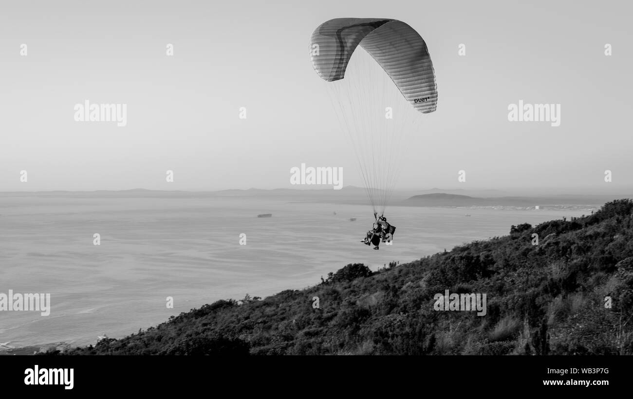 Ein Tandem Gleitschirm startet auf den Hängen des Signal Hill oberhalb der Stadt Kapstadt Südafrika auf der atlantischen Küste Stockfoto