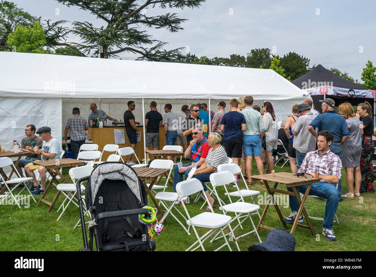 Die Menschen in der Warteschlange Getränke an der Bar im Garten an der Helmingham Festival der Klassischen & Sportwagen 2019 zu erhalten Stockfoto