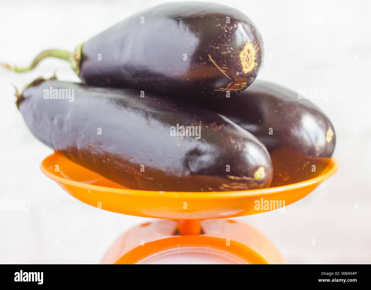 Frische rohe Violett Aubergine in einem speziellen Weidenkorb für Auberginen auf grau Holz- Hintergrund. Ansicht von oben, leeren Raum. Stockfoto