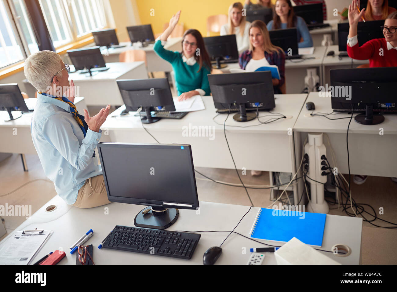 Professor während Vortrag auf dem Campus der Universität am Computer mit Studenten Stockfoto