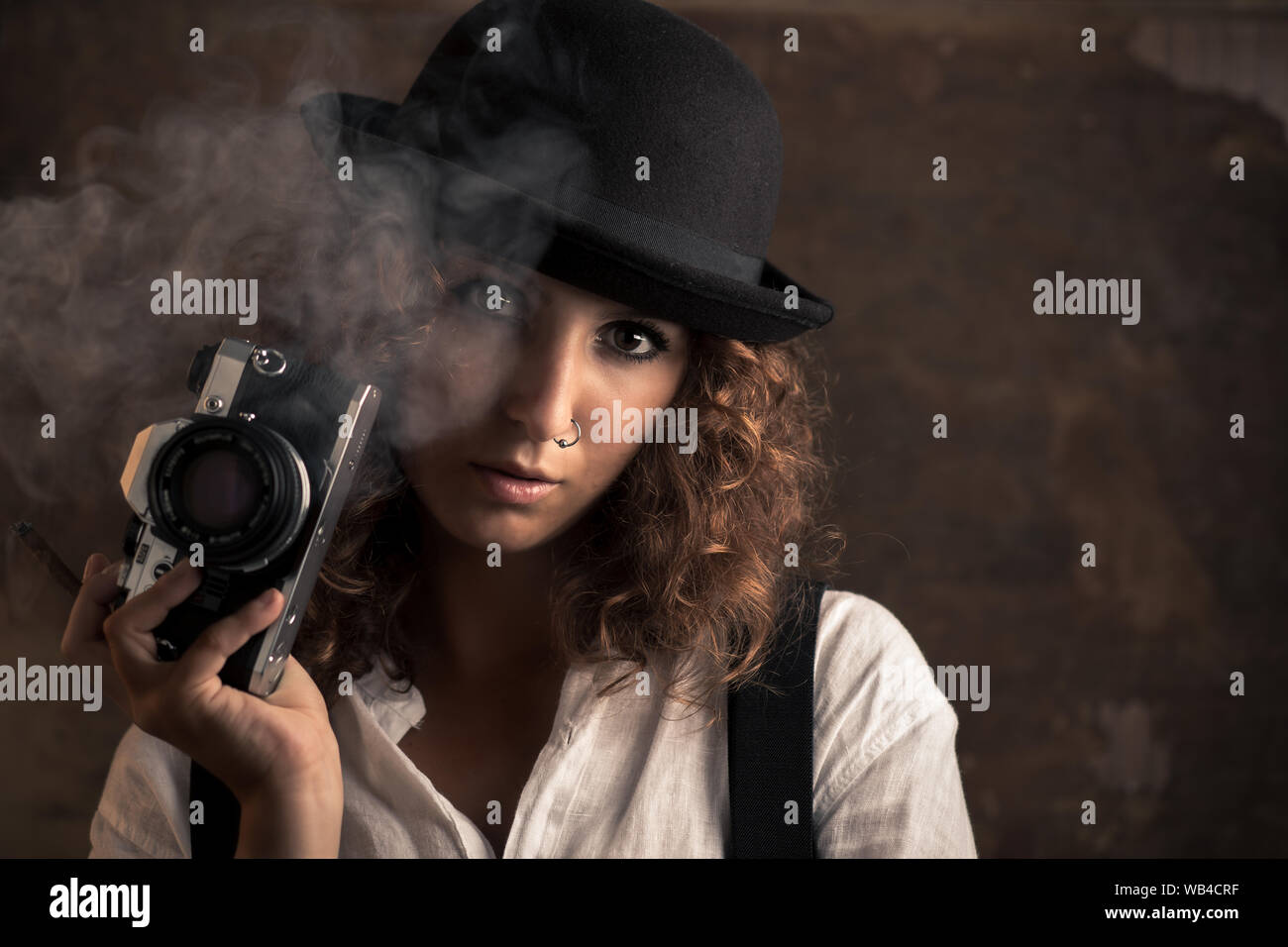 Fotografin mit Bowler und Hosenträger Holding eine Zigarre Stockfoto