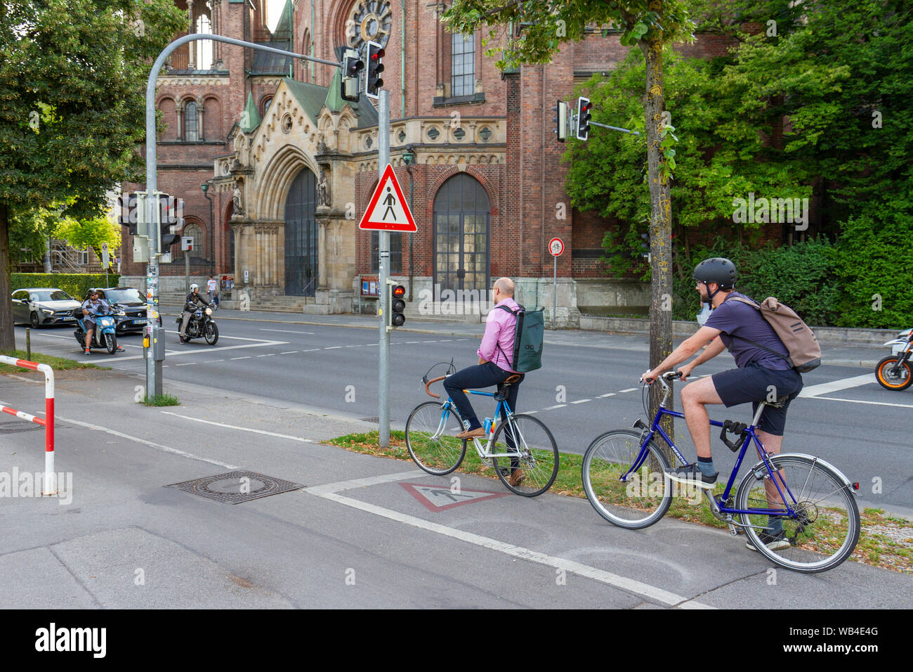 Radfahrer in einem Gehweg Radweg an einem Fahrrad rotes Licht warten (das entspricht dem Verkehr rotes Licht) in München, Bayern, Deutschland. Stockfoto