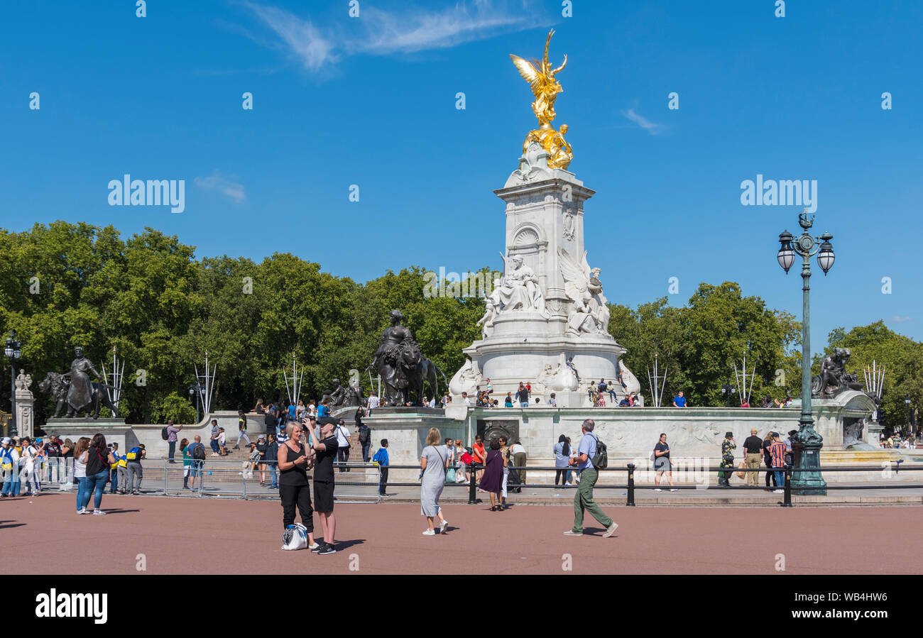Touristen an der goldenen Statue auf der Queen Victoria Memorial am Buckingham Palace, Westminster, London, UK. Stockfoto