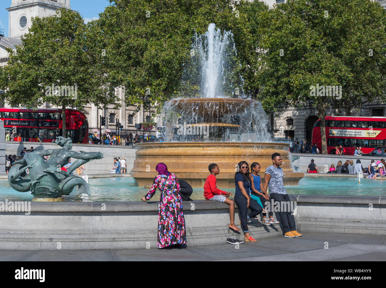 Brunnen und Touristen auf dem Trafalgar Square, Charing Cross, Westminster, London, England, UK. Stockfoto