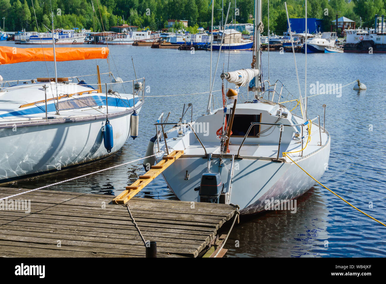 Kleine Segelboote günstig an einer hölzernen Pier Stockfoto