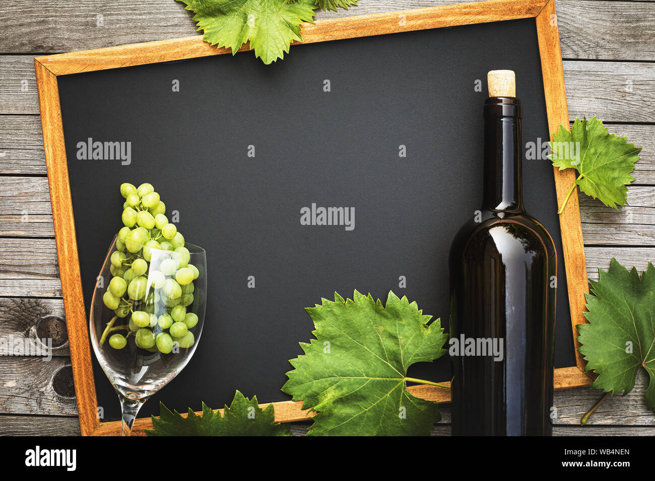 Flasche Wein mit einem Glas und Trauben auf einem Holztisch mit Kopie Raum, Ansicht von oben. Wein Business Konzept Stockfoto