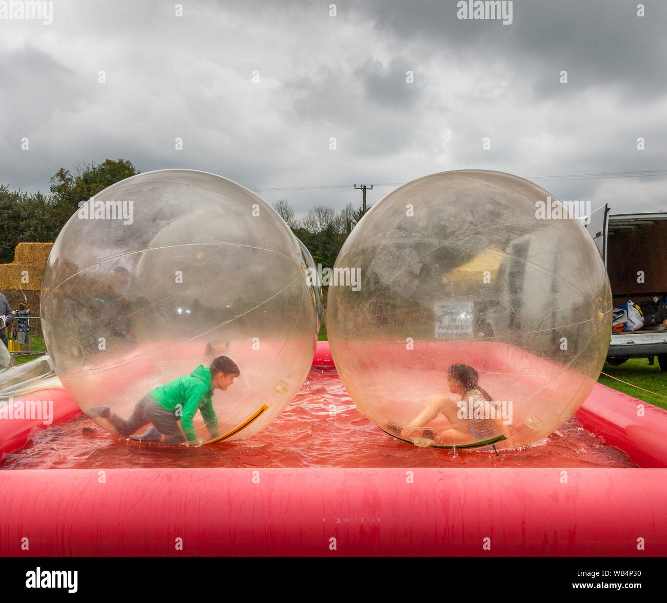 Ballygarvan, Cork, Irland, 24. August 2019. Junge und Mädchen spielen in riesigen schwimmenden Bällen auf der Ballygarvan Agricultural Show in Cork. - Guthaben; David Creedon / Alamy Live News Stockfoto