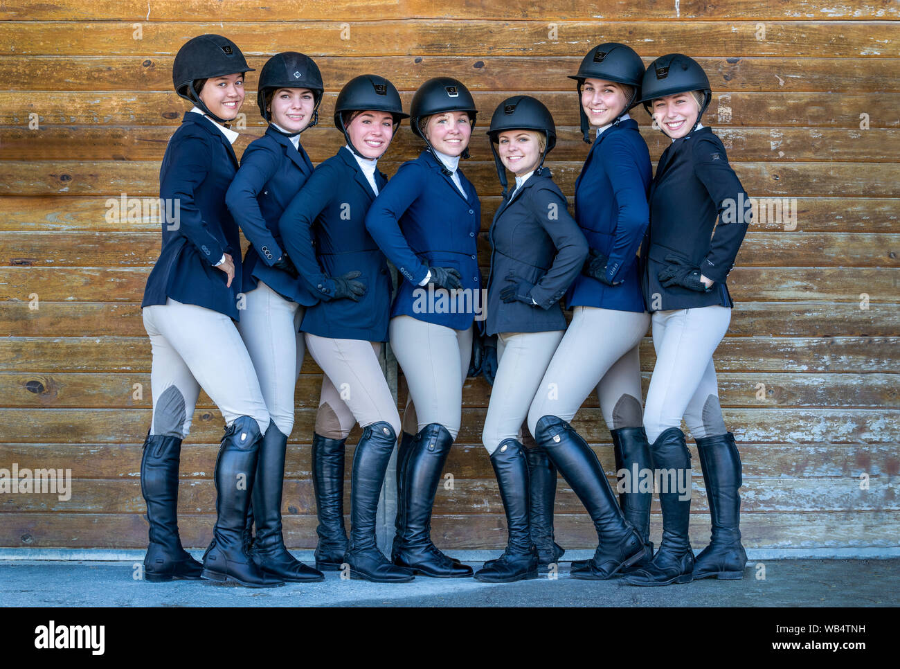 Eine Gruppe von Pferdesport high school Mädchen gekleidet in Show Kleider sind für die Kamera posieren Stockfoto