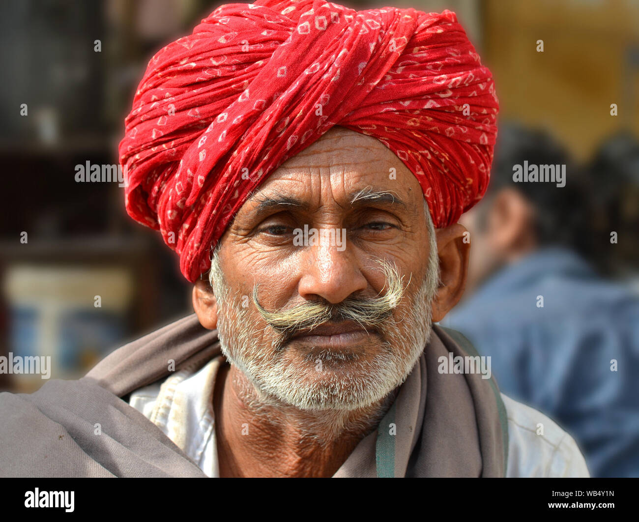 Ältere indische Rajasthani Mann mit rotem Rajasthani Turban (pagari) und gepflegte, grau Lenker Schnurrbart posiert für die Kamera. Stockfoto