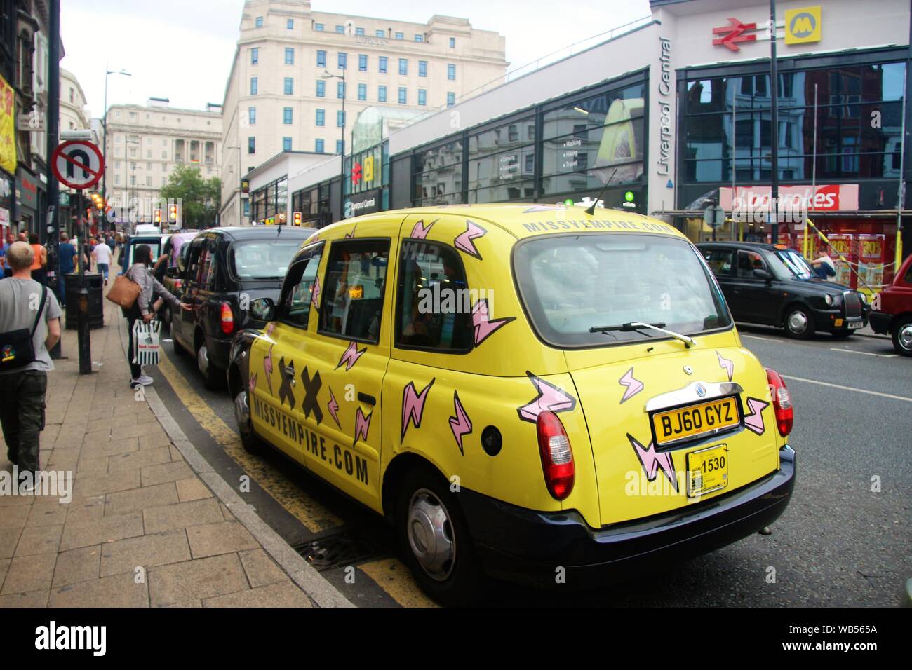 Straßenszene in Liverpool Lime Street. Ein Taxi in Pop Stil gemalt. Liverpool Station auf der gegenüberliegenden Seite. England, Europa. Stockfoto