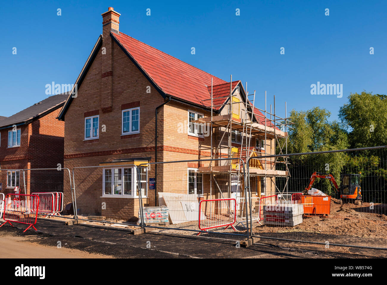 Neue Häuser bauen, England, UK. Neues Haus Baustelle mit Gerüst im Sommer. Neue Wohnsiedlung gebaut. Stockfoto