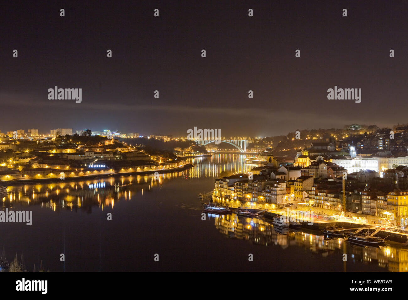 Der Fluss Douro (Rio Douro) und die malerische Stadt Porto mit dem Ponte da Arrábida, im Hintergrund, in der Nacht, Portugal. Stockfoto