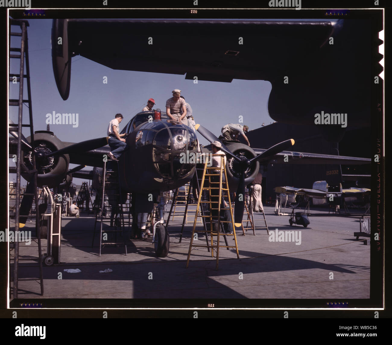 Die Mitarbeiter an der Sunshine Montageband nordamerikanische Werk den letzten Schliff an einem anderen B-25 Bomber, Inglewood, Kalifornien, Neben der Kampferprobte B-25 (Billy Mitchell) Bomber, in der Allgemeinen Doolittle Raid auf Tokio verwendet, in diesem Werk werden die P-51 (Mustang) Jagdflugzeug, das zunächst in den Vordergrund wurde von der britischen Raid auf Dieppe Abstract / Medium: 1 Transparenz: Farbe. Stockfoto