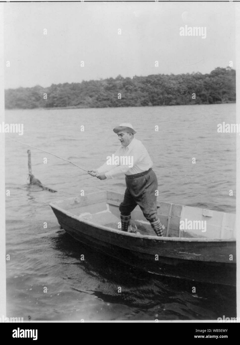 Enrico Caruso, 1873-1921, full-length Portrait, stehend, nach links weist, im Boot, an seinem Haus, Easthampton [d. h., East Hampton?], Angeln, mit Stick als Angelrute (?) Zusammenfassung/Medium: 1 Fotoabzug. Stockfoto