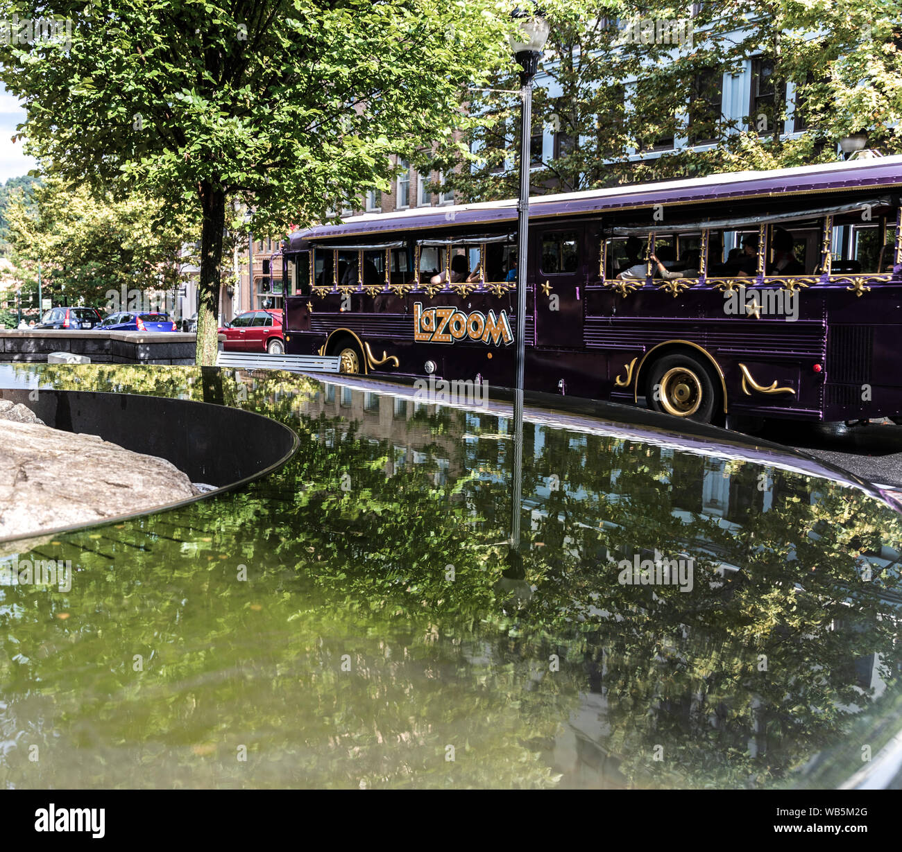 ASHEVILLE, NC, USA-21 August 2019: ein LaZoom Tourist Bus fährt ein reflektierendes Wasser Anzeige in Pack Square Park. Stockfoto