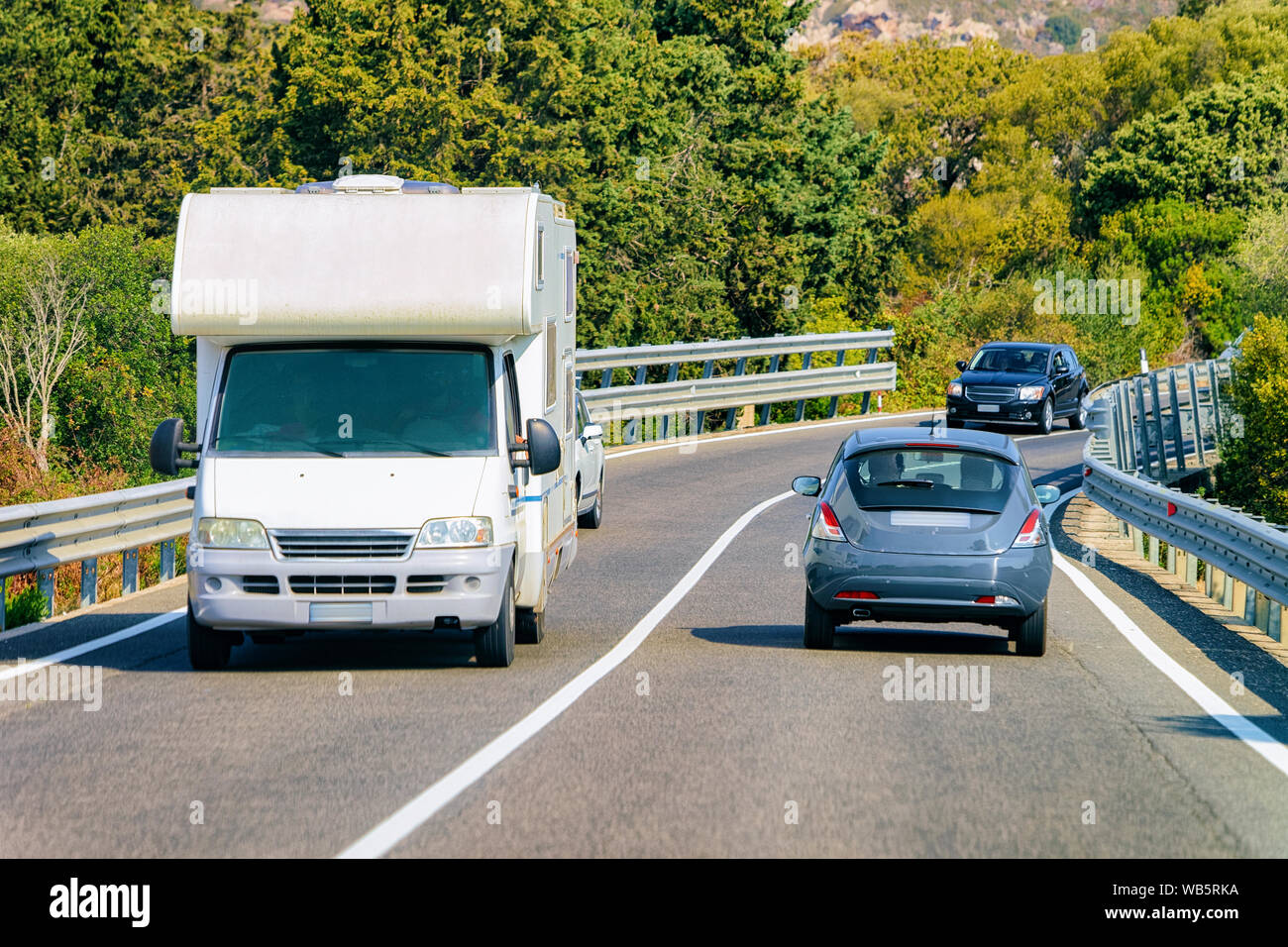 Rv cavaran und Autos in der Straße an der Costa Smeralda auf Sardinien in Italien im Sommer. Reisemobil rving auf der Autobahn. Camper Trailer auf der Autobahn. Stockfoto